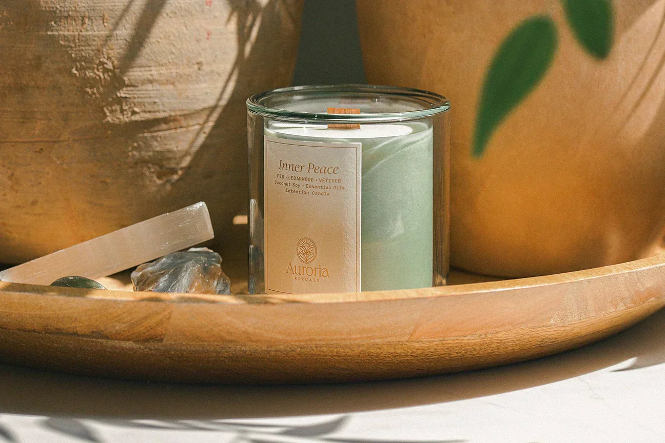 Natural non toxic candle with coconut soy wax, essential oils and crackling wood wick in glass vessel next to selenite and crystals